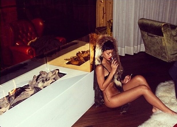 Rihanna poses semi-nude by a fireplace. Taken by Melissa Forde