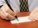 Stock image of man writing cheque